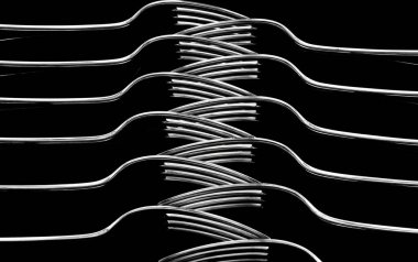 An artistic arrangement of stainless steel forks on a black background. clipart