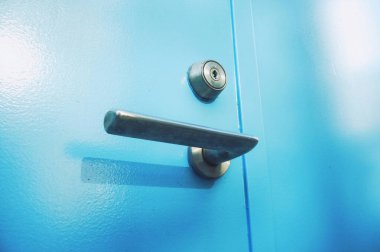 Close-up of a blue door with a metallic handle and lock. clipart