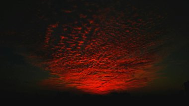 Stunning twilight sky with vibrant red and dark clouds. clipart