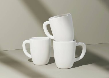 Three stacked white mugs in soft lighting, showcasing minimalist design. clipart