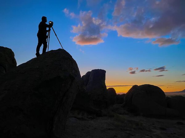 Photographer shooting sunset shot at City of Rocks, New Mexico USA.