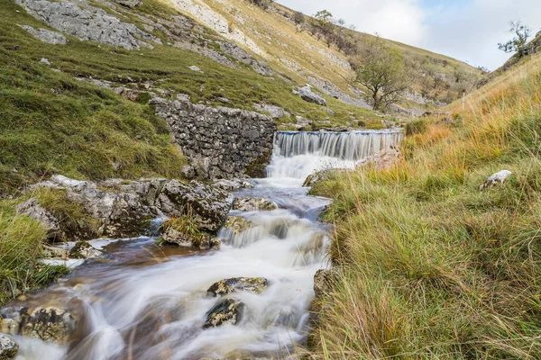 stock image Fast flowing water captured as a long exposure flows over rocks along Bucken Beck in the Yorkshire Dales.