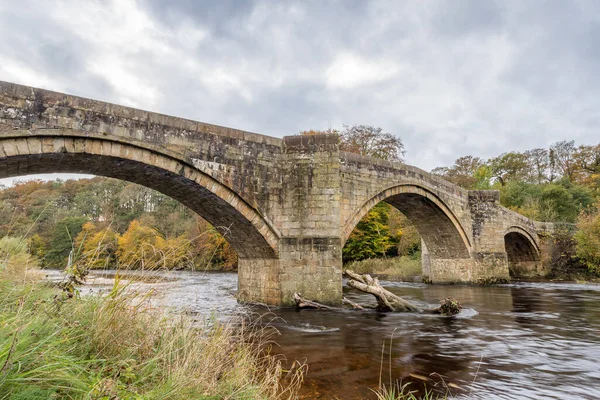 The fast flowing River Wharfe passes under Barden Bridge in the heart of the Yorkshire Dales pictured in the autumn of 2022.