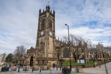 A high dynamic range image of Manchester cathedral seen in February 2023 under clouds.