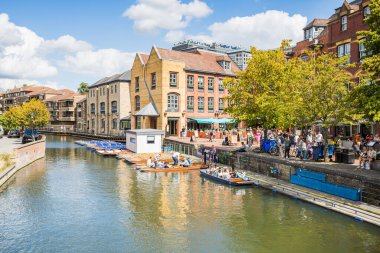 Turistler, Ağustos 2023 'te Cambridge' in Quayside bölgesinde teknelerin onları nehir kamerasıyla götürmesini beklerken çekildiler..