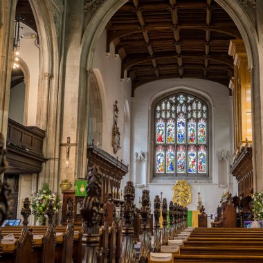 Ağustos 2023 'te Cambridge' de görülen büyük vitraylı pencereye doğru Büyük St Marys Kilisesi 'ndeki sıralara bakıyorum..