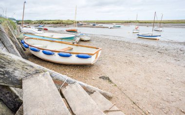 Tahta merdivenler kıyıya iniyor ve Burnham Overy Staithe 'deki tekneler Ağustos 2023' te resmedildi..