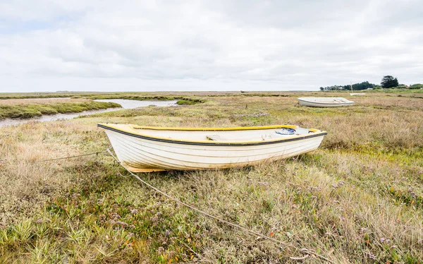 stock image Three small boats tied up on the marshes at Brancaster Staithe surrounded by sea lavender and the winding channels which lead out to the North Norfolk coast.