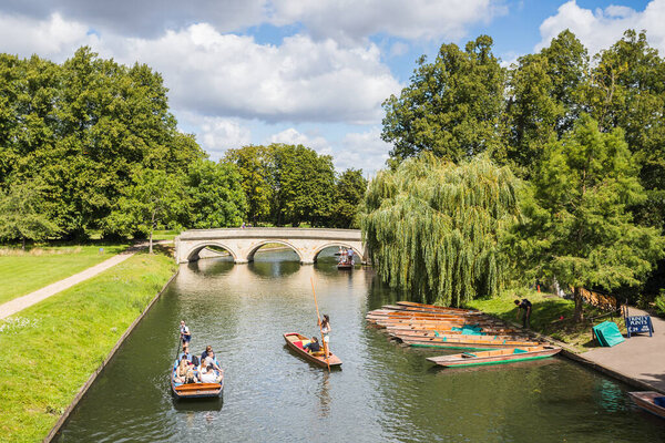 Punts taking tourists along the River Cam pictured in August 2023 in front of Trinity Bridge, Cambridge.