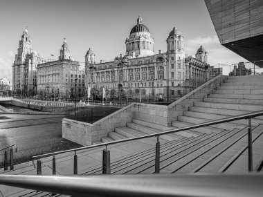 1 Ocak 2024 'te Liverpool rıhtımındaki Three Graces' in siyah beyaz bir görüntüsü.