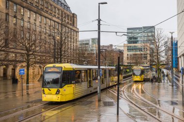 2 Ocak 2024 tarihinde Manchester Metrolink taşıma ağındaki St Peters Meydanı istasyonunda bir çift tramvay birbirinin yanından geçer..