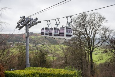 Cable car cabins of the Heights of Abraham seen moving through the trees in Matlock Bath, Deryshire pictured in April 2024. clipart
