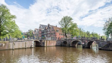 Hollanda, Amsterdam 'daki Prinsengracht Kanalı, 26 Mayıs 2024' te bisiklet ve insanların üzerinden geçtiği başka bir kanalla birleşir..