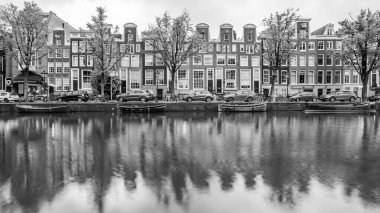 28 Mayıs 2024 'te Hollanda, Amsterdam' daki Prinsengracht kanalındaki evlerin siyah beyaz yansımaları.