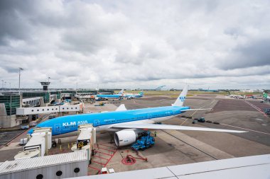 Hollanda, Amsterdam Schiphol Havaalanı 'ndaki bir kapı tarafından çekilen bir KLM uçağı, 29 Mayıs 2024' te aynı uçak gemisinden kalkan başka bir uçağın kalkışı için hazırlanıyor..