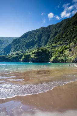 Portekiz 'in Madeira Adası' nın kuzeybatısındaki Seixal 'da 1 Ağustos 2024' te kara volkanik kumsalın keyfini çıkaran insanlar.