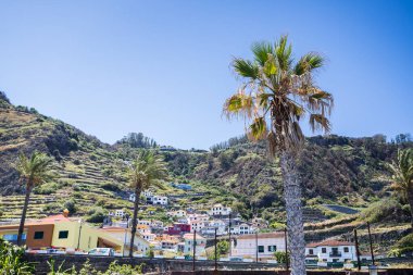 Madeira 'nın kuzey kıyısındaki tipik bir dik yamaçta yamaçlarda renkli evler inşa edilir..