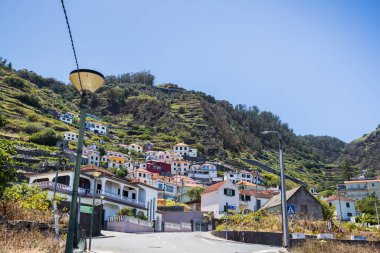 Portekiz 'in Madeira Adası' nın kuzey kıyısında 1 Ağustos 2024 tarihinde Porto Moniz 'e bakan renkli evler,.