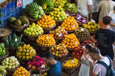 Turistler, 6 Ağustos 2024 'te Madeira' nın Funchal kentindeki Mercado dos Lavradores pazarında görülen renkli taze meyvelerden bazılarını tadıyorlar..