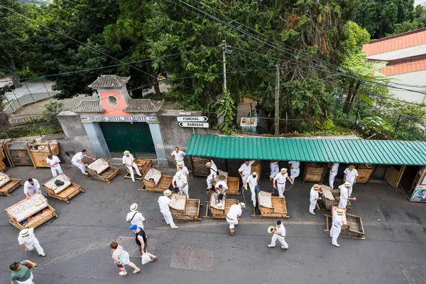 stock image Workers on the tourist toboggans made of Camacha wicker wait for customers wanting to ride down to Funchal, Madeira seen on 31 July 2024.