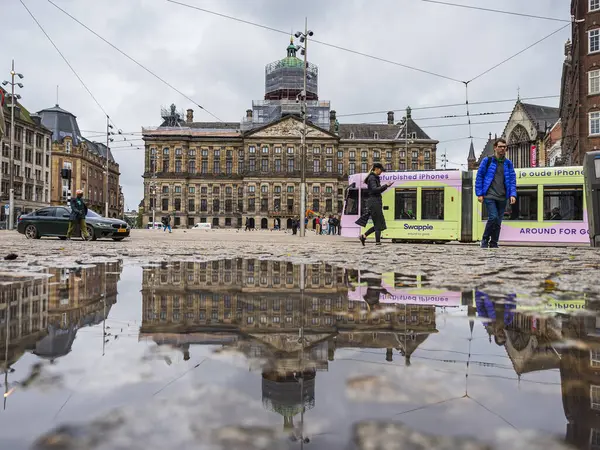 29 Mayıs 2024 'te Hollanda, Amsterdam' daki Baraj Meydanı 'ndan renkli bir tramvay geçer..