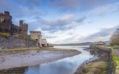 Conwy Kalesi ve Conwy Askı Köprüsü 'nün yanında Conwy Nehri' nin kıvrımlı bir kolundaki değişen gökyüzünün yansımaları..