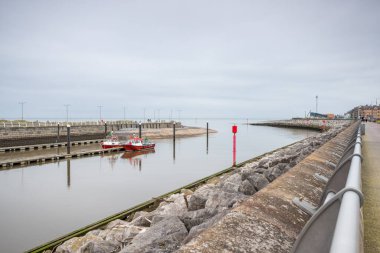 Red and white fishing boats outside Rhyl harbour on the Wales coastline at the start of the River Clwyd on 30 October 2024. clipart