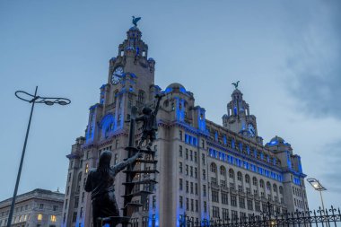 24 Kasım 2024 'te hava kararırken Royal Liver Binası' nın önündeki Blitz anıtına bakıyorum..