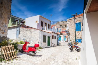 17 Nisan 2025 'te Yunanistan' ın Chalki kentinde dar bir yolda çeşitli renkli motorlu araçlar görüntülendi.