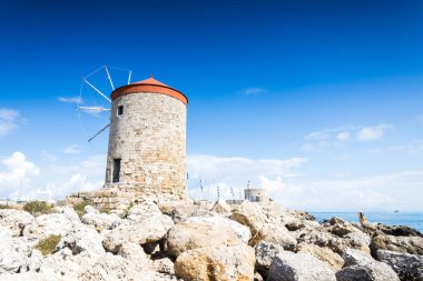 Rodos 'un Rodos' taki Neoriou Rıhtımı 'nda konuşlandırılan üç rüzgar değirmeninden biri, 5 Nisan 2025' te mavi gökyüzünün altında resmedildi.