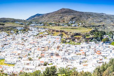Rodos 'taki Lindos Akropolis' in avantajlı noktasından görülen Lindos 'un beyaz yıkanmış evlerini izliyorlar..