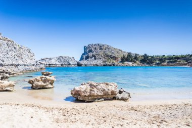 Dalgalar Yunanistan 'ın Rodos kentindeki Mikros Gialos plajının altın kumlarına nazikçe çarpıyor.