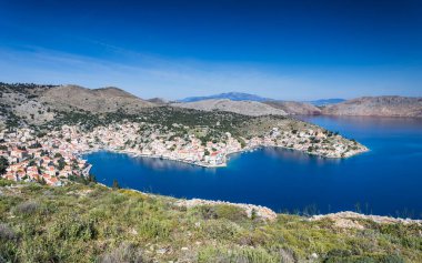 Symi 'nin Yunanistan' daki ana kasabasını çevreleyen gök mavisi sularda yüksek bir bakış açısına sahip..