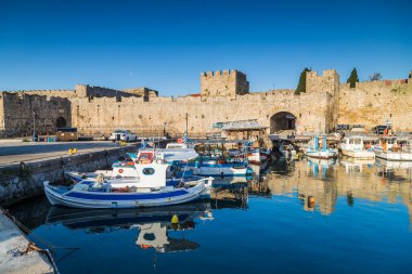 Rodos limanındaki balıkçı tekneleri, 17 Nisan 2025 'te Yunanistan' da sabahın erken saatlerinde altın ışıkla aydınlandı..