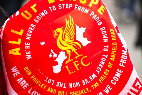 26 Mayıs 2025 'te Liverpool, Liverpool yakınlarında Liverpool Premier Lig şampiyonları geçit töreninde görülen bir fanın etrafına sarılmış Allez Allez pankartı.