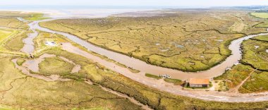 Kuzey Norfolk kıyısındaki Thornham 'daki Kömür Ambarı' nın çok görüntülü manzarası bataklıklar ve dar kanallarla çevrili..