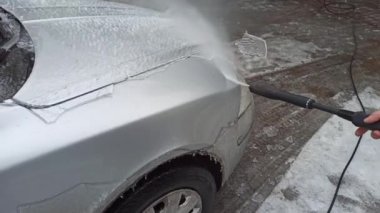 Yağmurdan ve soğuktan sonra basınçlı su jeti ile buz arabasının temizlenmesi. 