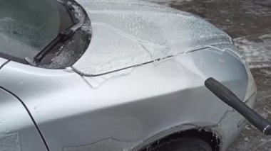 Yağmurdan ve soğuktan sonra basınçlı su jeti ile buz arabasının temizlenmesi. 