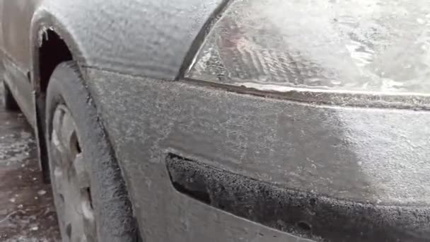 冬の雨で凍えるような夜の後駐車場に氷の層で覆われた乗用車 — ストック動画