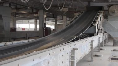 Tahıl taşıyıcı bant boyunca hareket eder. Buğday, değirmende kurutulup öğütülmeye taşınır. Buğday un haline getirilir. Taşıyıcıda buğday taneleri var. Değirmendeki tahıl ambarı..