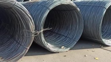 Alıcıya nakledilmek üzere bir gemiye yüklenmeden önce bir rıhtımdaki bobinlere tel yerleştirmek.
