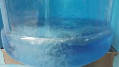 Plastik şişeyi 18 litrelik bir kapasiteyle içme suyu ile doldurmak. 