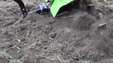 Çiftçi arazideki toprağı işlemek için motorlu ekiciyle çalışıyor. Ekinleri ve otları ayıklamak, toprağı sürmek.