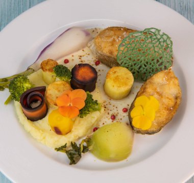 Recipe of cod steak, mashed potatoes and its farandole of vegetables, parsnip, turnip, broccoli, candied potato. High quality photo