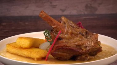 Kızarmış polenta, havuç, şalgam, mantar ve sos ile servis edilen kuzu güveci turtası.