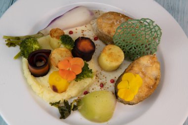 Recipe of cod steak, mashed potatoes and its farandole of vegetables, parsnip, turnip, broccoli, candied potato. High quality photo