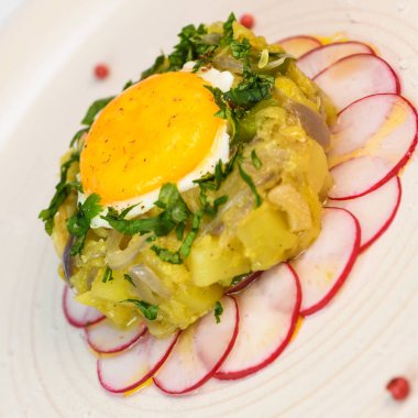 Kabak eti, soğan, patates, sarımsak, biber, kişniş ve yumurta sarısı. Yuvarlak turp yatağında kızartılmış.