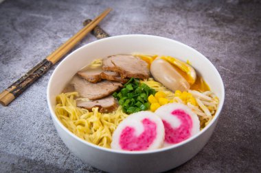 Garnitürlü erişte, domuz filetosu, Mirin 'de marine edilmiş yumurta ve soya sosu, fasulye filizi, mısır, nori yaprağı, taze soğan ve morina balıklı ev yapımı Narutomaki.