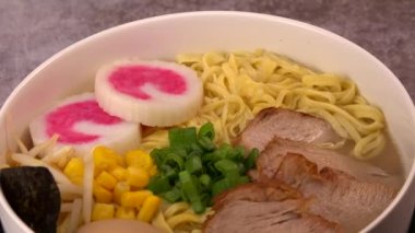 Garnitürlü erişte, domuz filetosu, Mirin 'de marine edilmiş yumurta ve soya sosu, fasulye filizi, mısır, nori yaprağı, taze soğan ve morina balıklı ev yapımı Narutomaki.