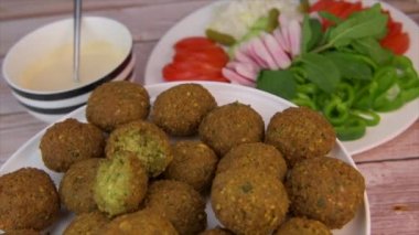Kızarmış falafel köftesi ve tahini sosu, doğranmış baklagiller ve nohut.